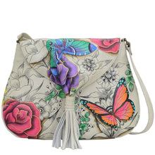 Load image into Gallery viewer, Anna by Anuschka style 8286, handpainted Flap Hobo. Floral Paradise painting in white color. Featuring one full length pocket with magnetic button under flap, Fits E-Reader, Fits tablet.
